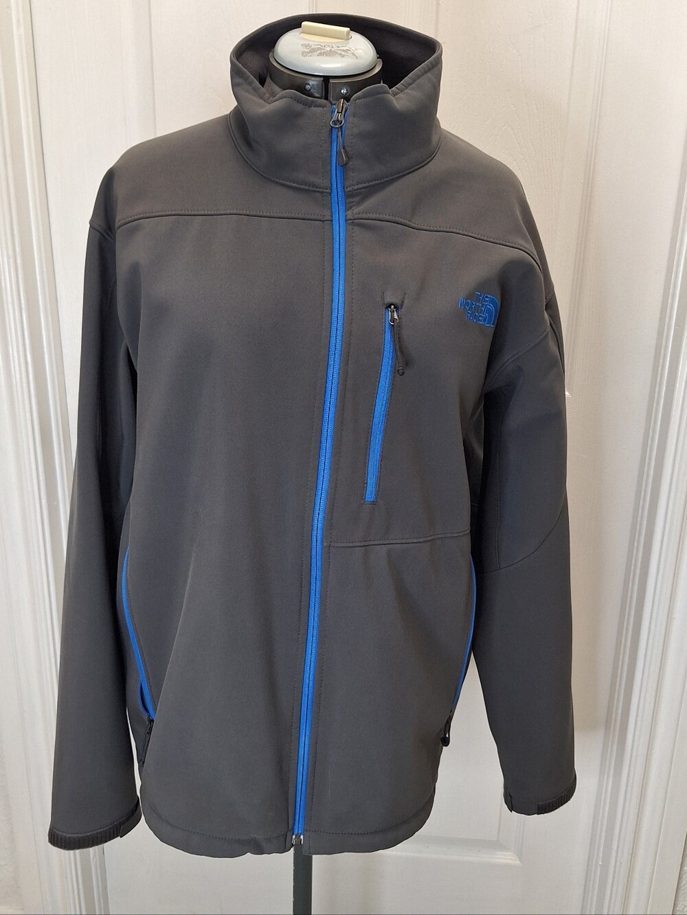 The North Face Men's Grey Softshell Jacket with Blue Trim.